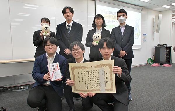 賞状・目録+学生7名の集合写真