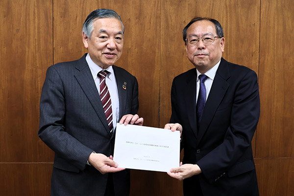 阿部多摩市長（左）へ報告書を提出する中庭教授（右）